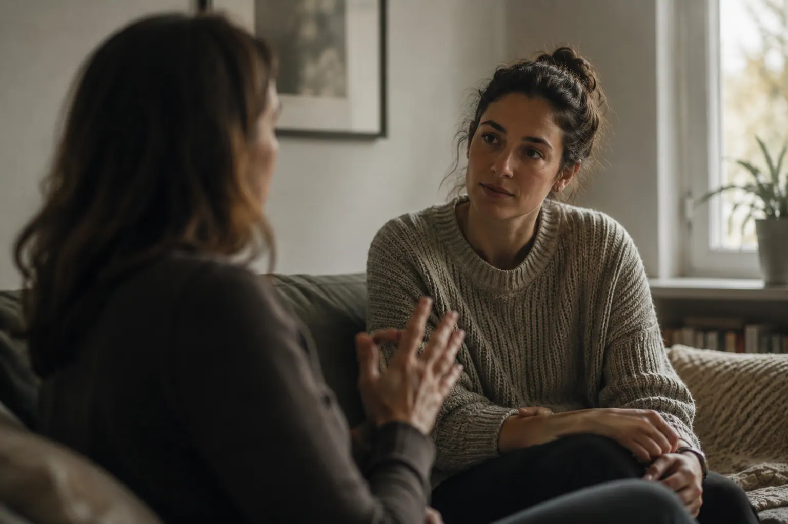 Two women talking privately over tea in a calm home-like setting